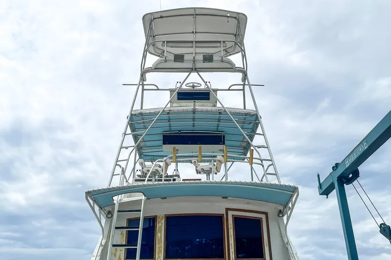 Slide: The Image of 1978 Bertram 46 Convertible yacht with tower against cloudy sky. - 21