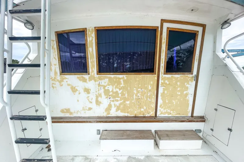 Slide: The Image of 1978 Bertram 46 Convertible boat with weathered exterior and wooden accents. - 34