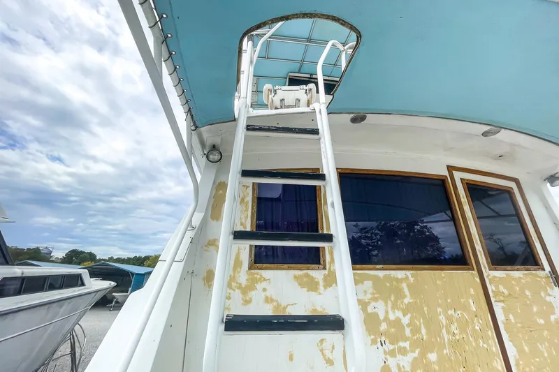 Slide: The Image of 1978 Bertram 46 Convertible boat ladder and cabin under blue sky. - 36