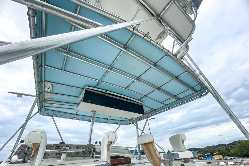 Slide: The Image of 1978 Bertram 46 Convertible boat with blue canopy and control panel. - 38