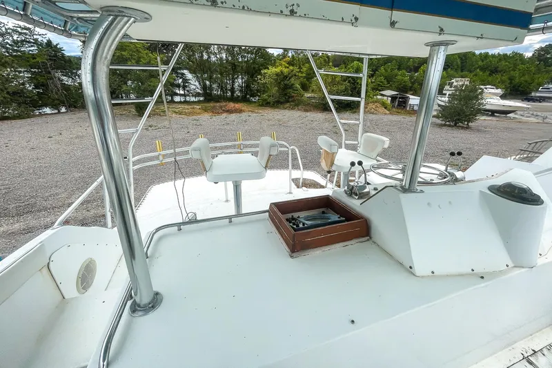 Slide: The Image of 1978 Bertram 46 Convertible boat deck with seating and controls, parked on gravel. - 45