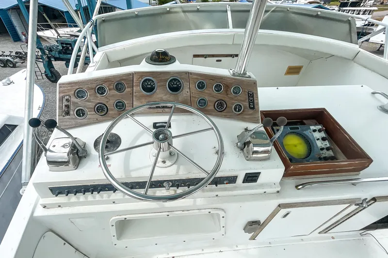 Slide: The Image of 1978 Bertram 46 Convertible yacht helm with steering wheel and control panel. - 48
