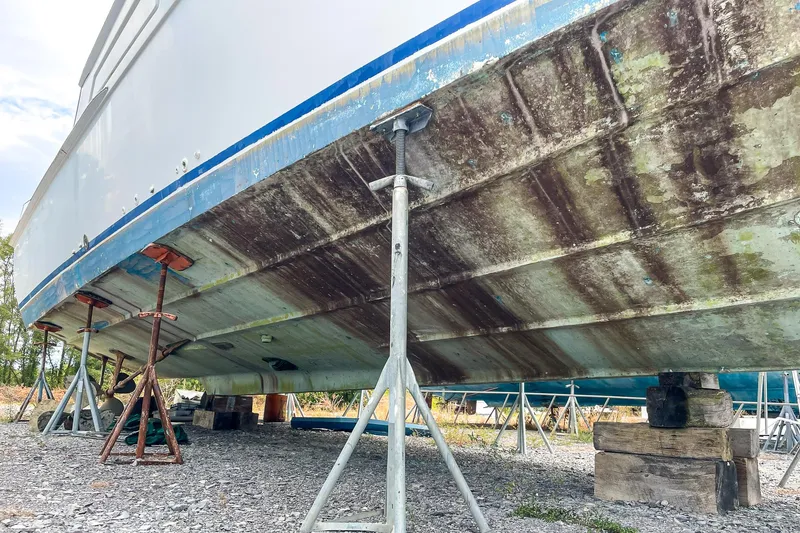 Slide: The Image of 1978 Bertram 46 Convertible boat hull on stands, showing weathered underside. - 8