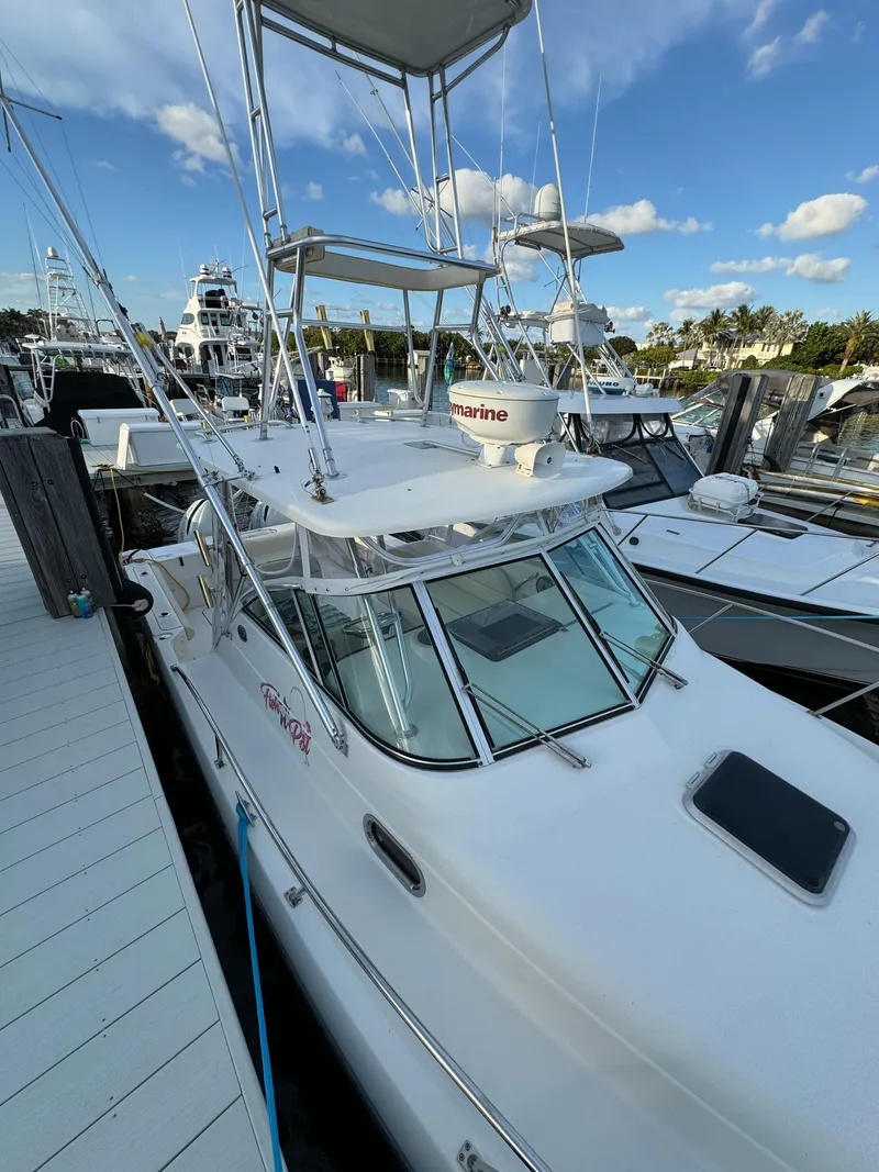 Slide: The Image of 2005 Pursuit 3070 WA EXPRESS boat docked at marina under blue sky. - 19