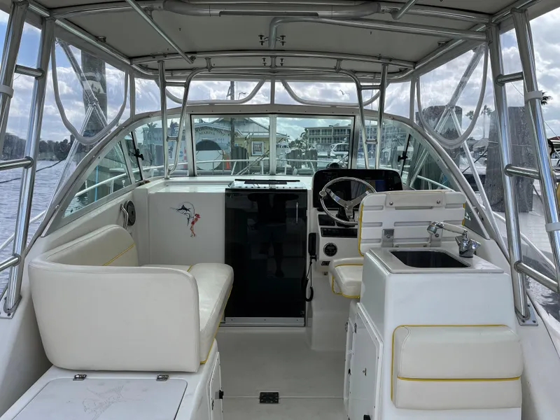 Slide: The Image of 2005 Pursuit 3070 WA EXPRESS boat interior with helm, seating, and sink. - 7
