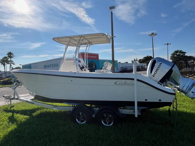 The Image of 2022 Cobia 237 Center Console boat with Honda engine on trailer, parked outdoors. - 0