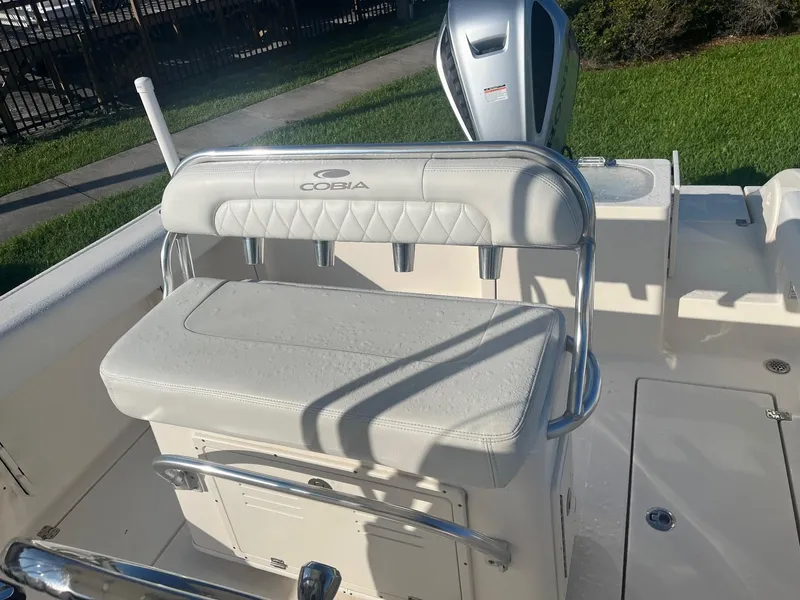 Slide: The Image of 2022 Cobia 237 Center Console boat interior with cushioned seating and motor. - 3