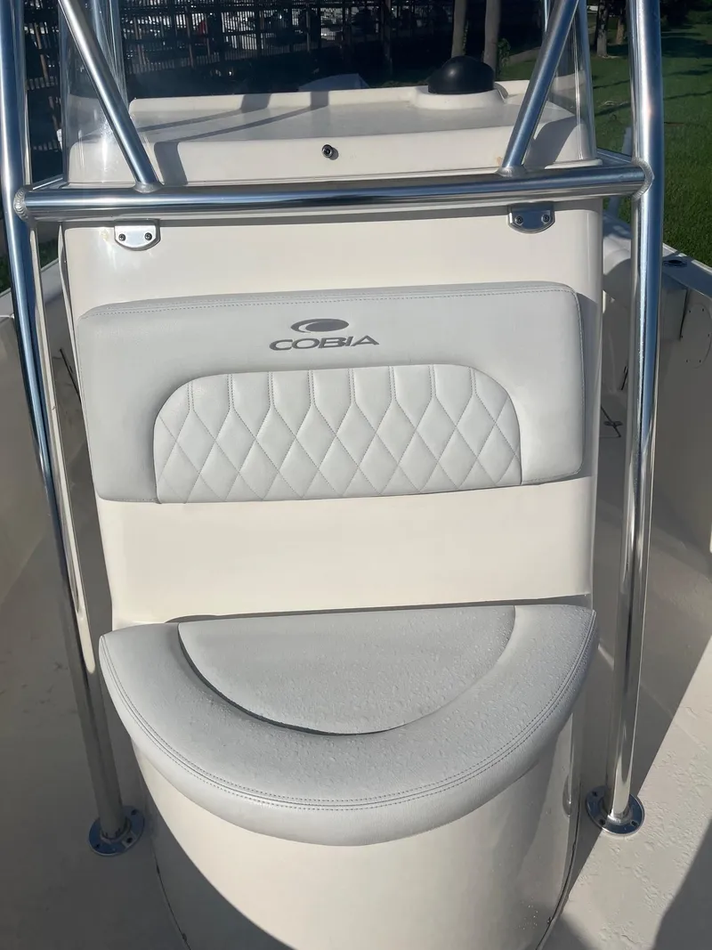 Slide: The Image of 2022 Cobia 237 Center Console boat seat with logo and stainless steel railing. - 4