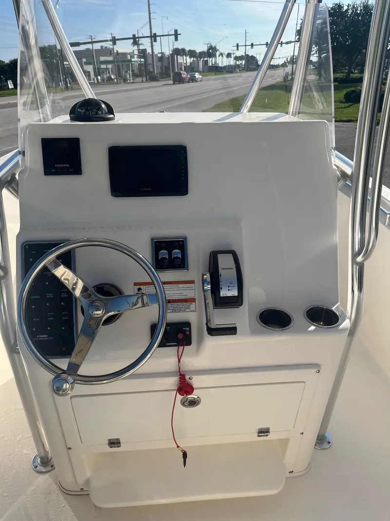 Slide: The Image of 2022 Cobia 237 Center Console boat dashboard with steering wheel and controls. - 6