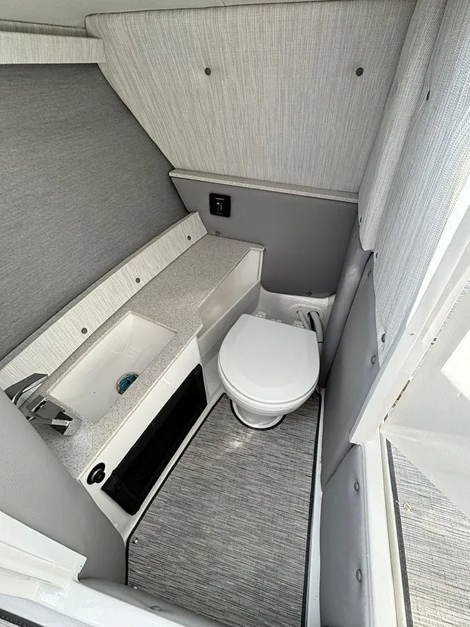 Slide: The Image of 2025 Cobalt R6 Outboard boat interior bathroom with modern sink and toilet. - 23