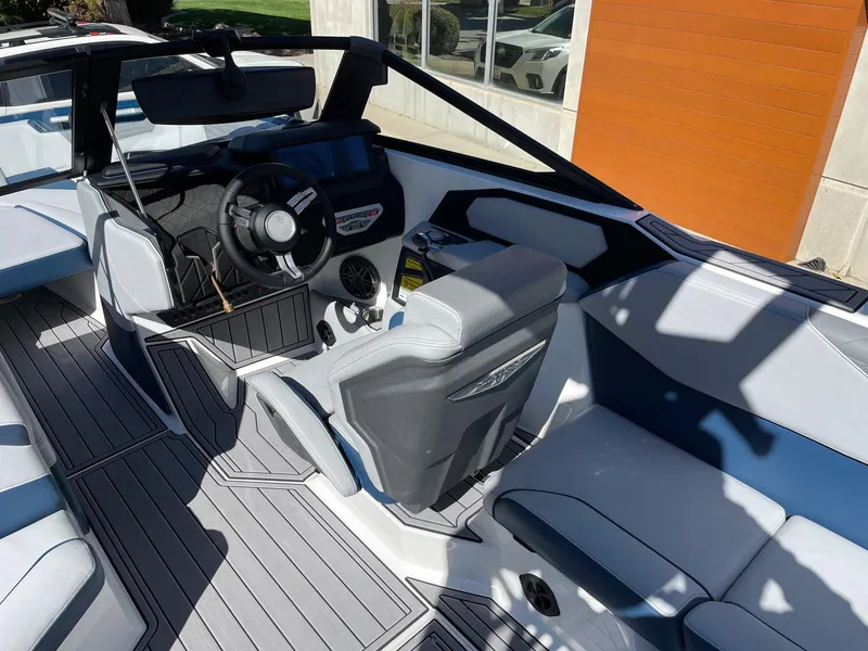 Slide: The Image of 2023 Nautique Super Air Nautique S25 boat interior with modern steering and seating. - 6