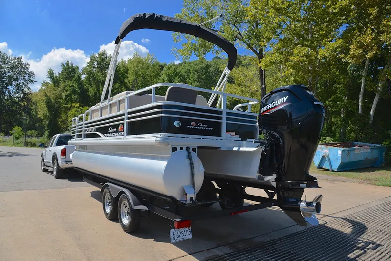 Slide: The Image of 2021 Sun Tracker Fishin Barge 20 DLX pontoon boat on trailer, parked outdoors. - 12