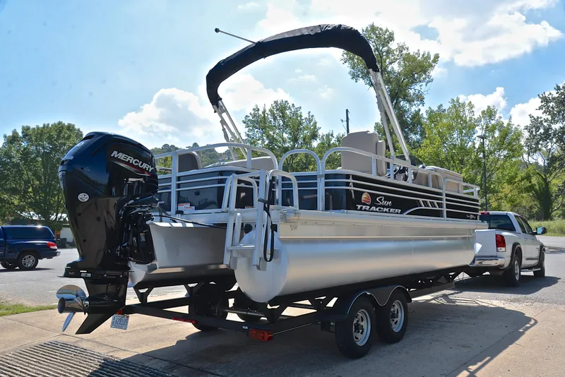 Slide: The Image of 2021 Sun Tracker Fishin Barge 20 DLX pontoon boat on trailer, parked outdoors. - 14
