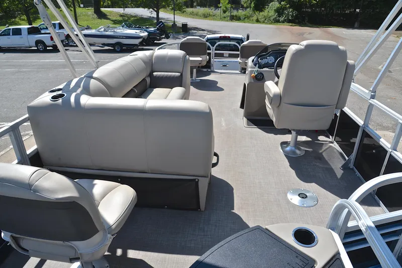 Slide: The Image of 2021 Sun Tracker Fishin Barge 20 DLX interior with beige seating and steering console. - 18