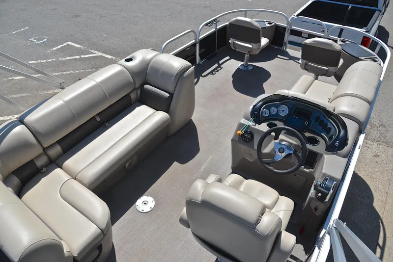 Slide: The Image of 2021 Sun Tracker Fishin Barge 20 DLX interior with beige seating and steering console. - 19