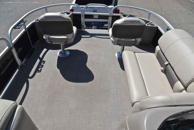 Slide: The Image of 2021 Sun Tracker Fishin Barge 20 DLX interior with beige seating and spacious deck. - 21