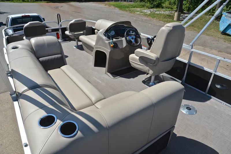 Slide: The Image of 2021 Sun Tracker Fishin Barge 20 DLX interior with beige seating and steering console. - 24