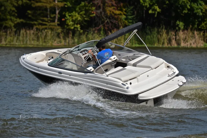 Slide: The Image of 2008 Chaparral 190 SSi boat cruising on a lake with lush greenery. - 6