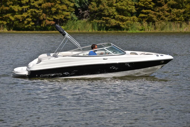 Slide: The Image of 2008 Chaparral 190 SSi boat cruising on a lake with lush greenery in the background. - 7