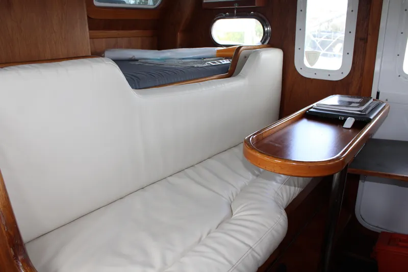 Slide: The Image of Interior of 2001 Nordhavn 40 yacht with white leather seating and wooden table. - 15
