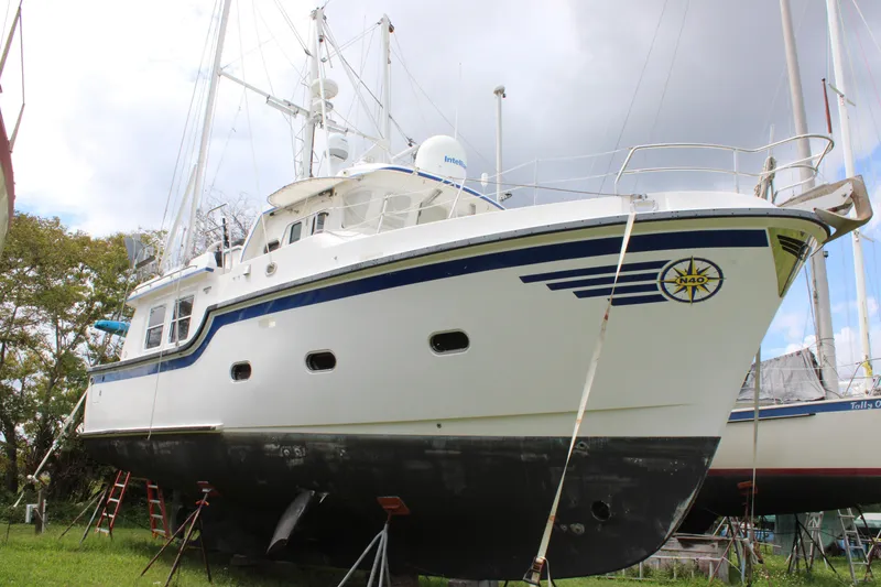 Slide: The Image of 2001 Nordhavn 40 yacht on land, white hull with blue accents, overcast sky. - 25