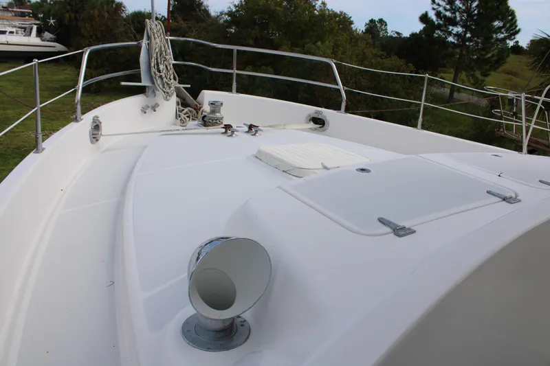 Slide: The Image of 2001 Nordhavn 40 yacht deck with railing and equipment, surrounded by greenery. - 31