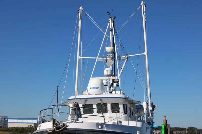 Slide: The Image of Nordhavn 40 boat, 2001 model, with tall masts against a clear blue sky. - 42