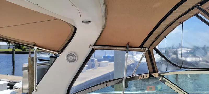 Slide: The Image of Interior view of 2000 Sea Ray 380 Sundancer boat with tan canopy and clear windows. - 23