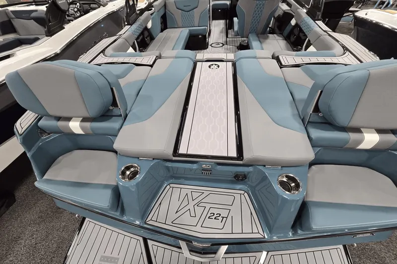 Slide: The Image of 2025 MasterCraft XT22 T boat interior with blue and gray seating, showcasing luxury design. - 15