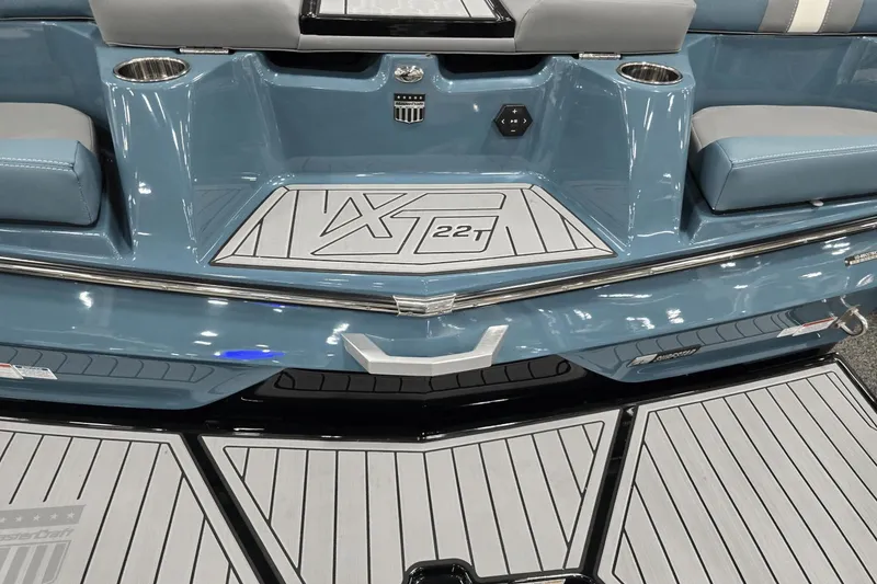 Slide: The Image of 2025 MasterCraft XT22 T boat interior with blue seating and branded flooring. - 16
