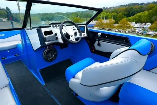 Slide: The Image of 2016 MasterCraft NXT20 boat interior with blue and white seating, steering wheel, and dashboard. - 15
