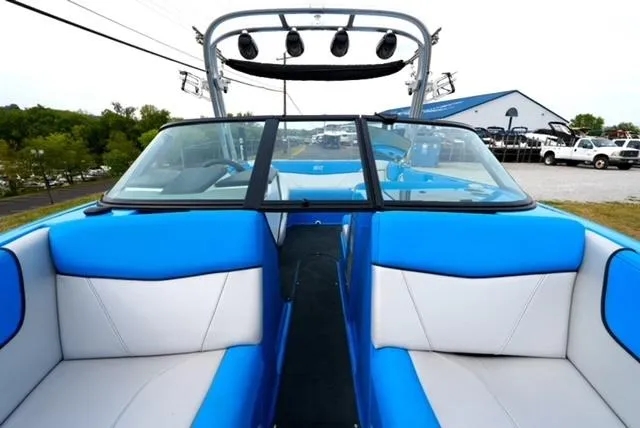 Slide: The Image of 2016 MasterCraft NXT20 boat interior with blue and white seating, open windshield, and tower speakers. - 16
