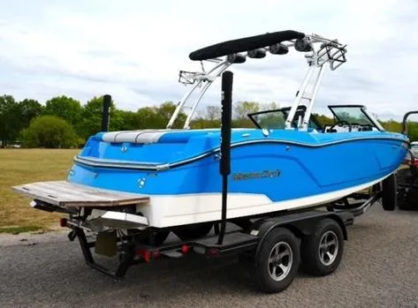 Slide: The Image of 2016 MasterCraft NXT20 boat in blue on a trailer, parked outdoors. - 3