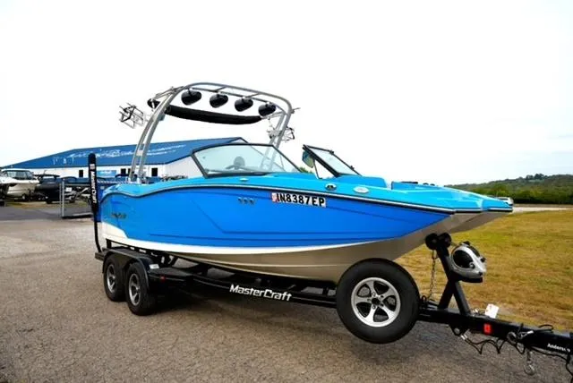Slide: The Image of 2016 MasterCraft NXT20 boat on trailer, vibrant blue color, parked outdoors. - 5