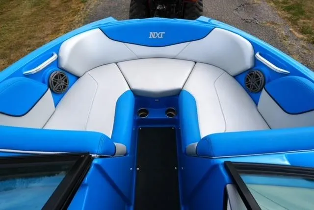 Slide: The Image of 2016 MasterCraft NXT20 boat interior with blue and white seating, featuring speakers and cup holders. - 8