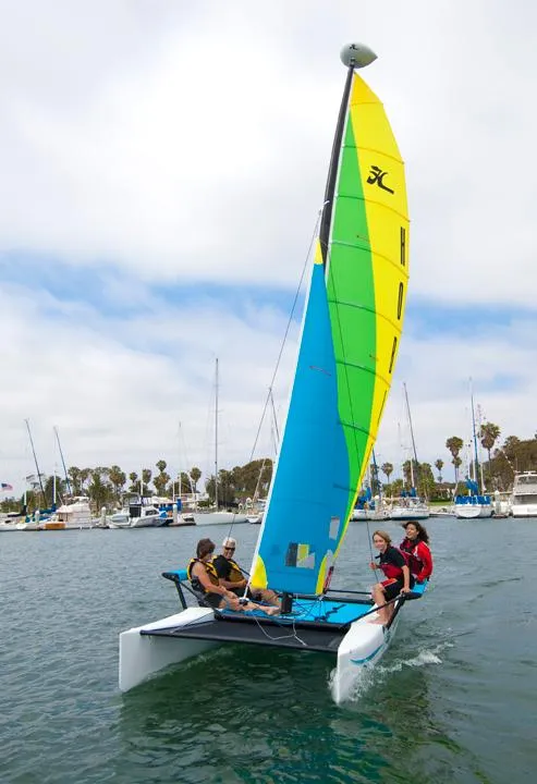 Slide: The Image of 2024 Hobie Cat Getaway sailing on a sunny day with passengers onboard. - 2