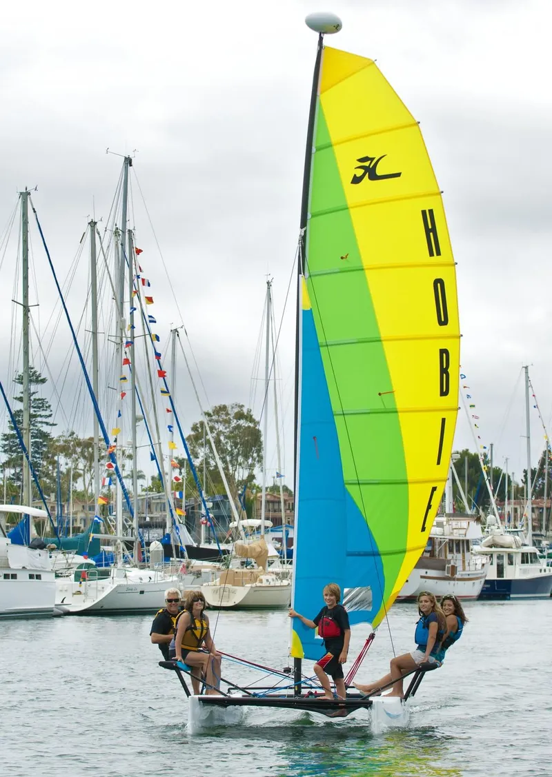 Slide: The Image of 2024 Hobie Cat Getaway sailing with group, vibrant sail, marina background. - 5