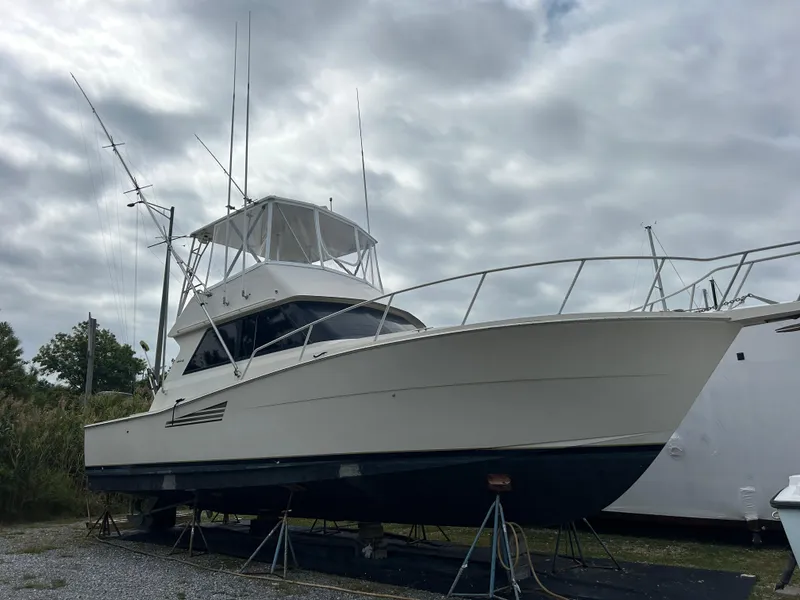 Slide: The Image of 1990 Viking 38 Convertible boat on stands under cloudy sky. - 1