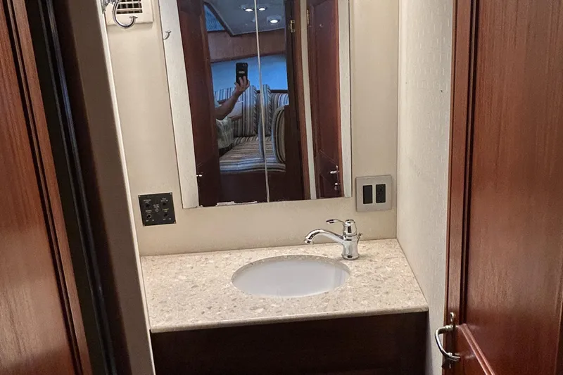 Slide: The Image of Bathroom vanity in 1990 Viking 38 Convertible yacht, featuring a sink and mirror. - 10