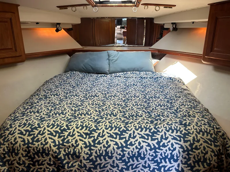 Slide: The Image of Cozy bedroom interior of 1990 Viking 38 Convertible yacht with patterned bedding. - 12