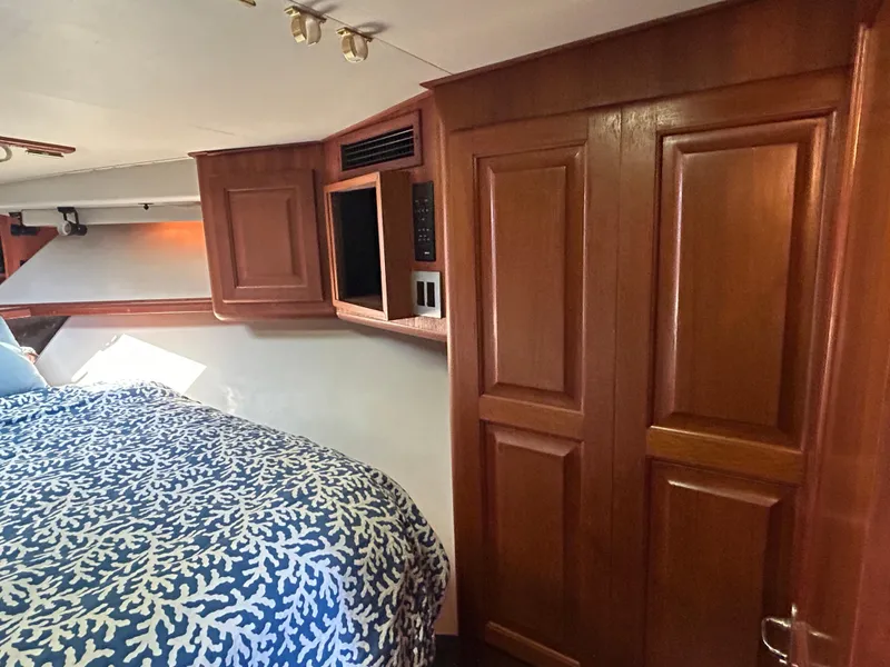 Slide: The Image of Interior of 1990 Viking 38 Convertible yacht with wood paneling and patterned bedding. - 13