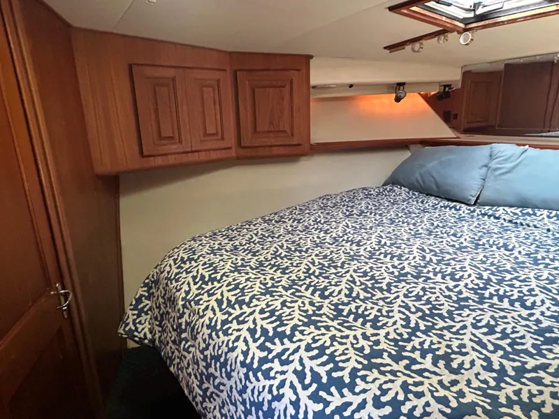 Slide: The Image of Cozy cabin interior of 1990 Viking 38 Convertible with patterned bedding and wooden cabinets. - 14