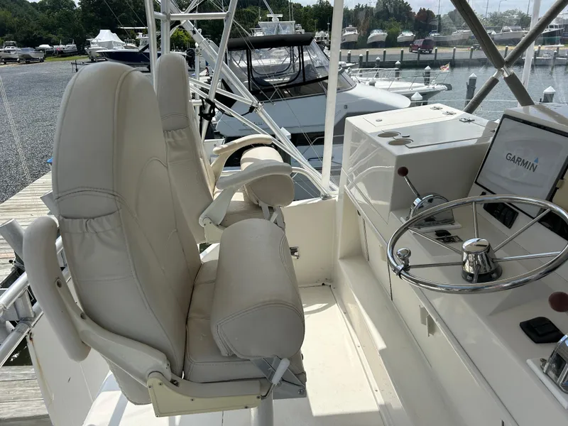 Slide: The Image of 1990 Viking 38 Convertible yacht helm with Garmin navigation, leather seats, and steering wheel. - 16