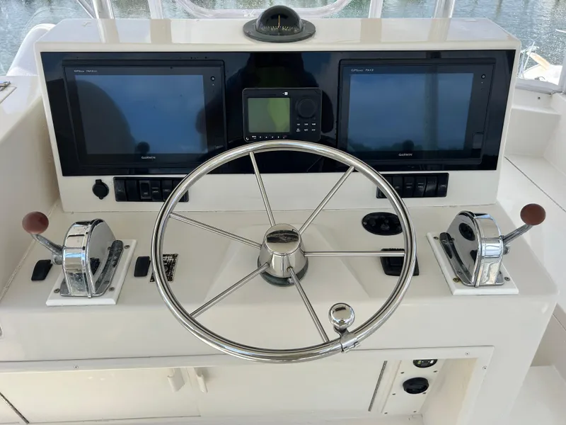 Slide: The Image of Helm of 1990 Viking 38 Convertible with dual Garmin displays and chrome steering wheel. - 17