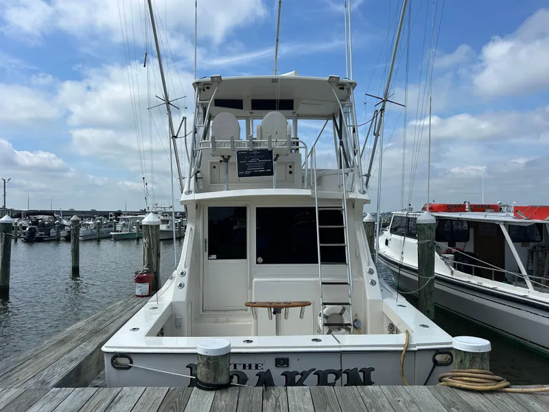 Slide: The Image of 1990 Viking 38 Convertible yacht docked at marina under blue sky. - 2
