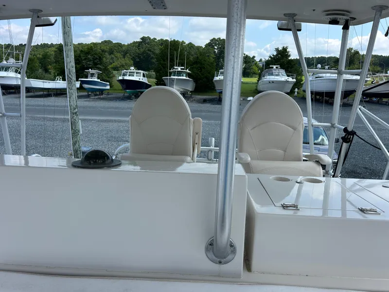Slide: The Image of 1990 Viking 38 Convertible boat interior with white seating, docked among other boats. - 21