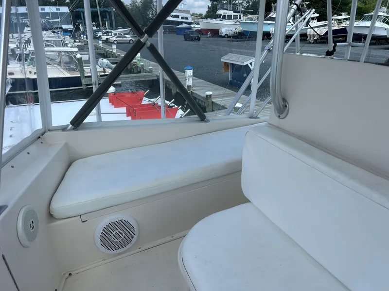 Slide: The Image of Interior view of 1990 Viking 38 Convertible yacht with white seating and marina background. - 22