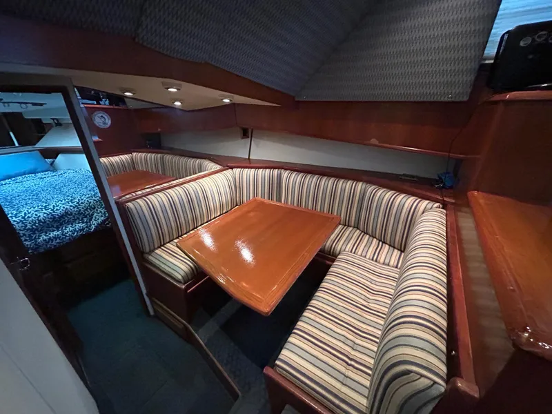 Slide: The Image of Interior of 1990 Viking 38 Convertible yacht with striped seating and wooden table. - 8