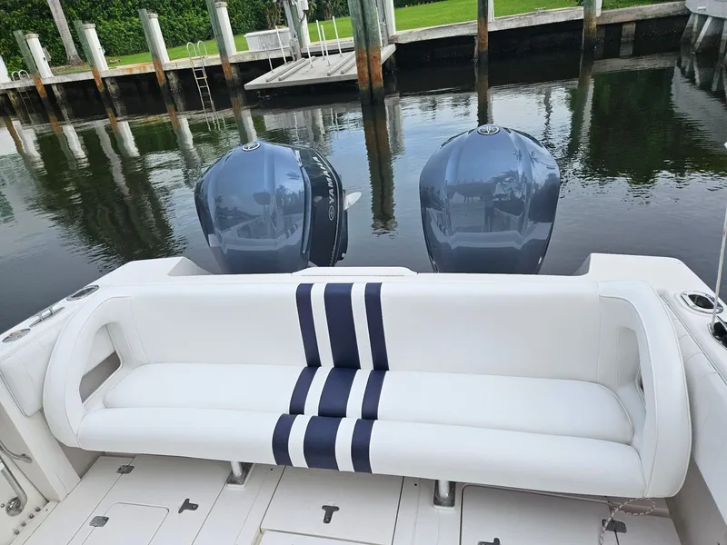 Slide: The Image of 2005 Intrepid 323 Cuddy boat with dual Yamaha engines and white seating at a dock. - 18