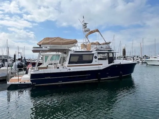 The Image of 2019 Ranger Tugs R-41 CB boat docked in a marina under a cloudy sky. - 0